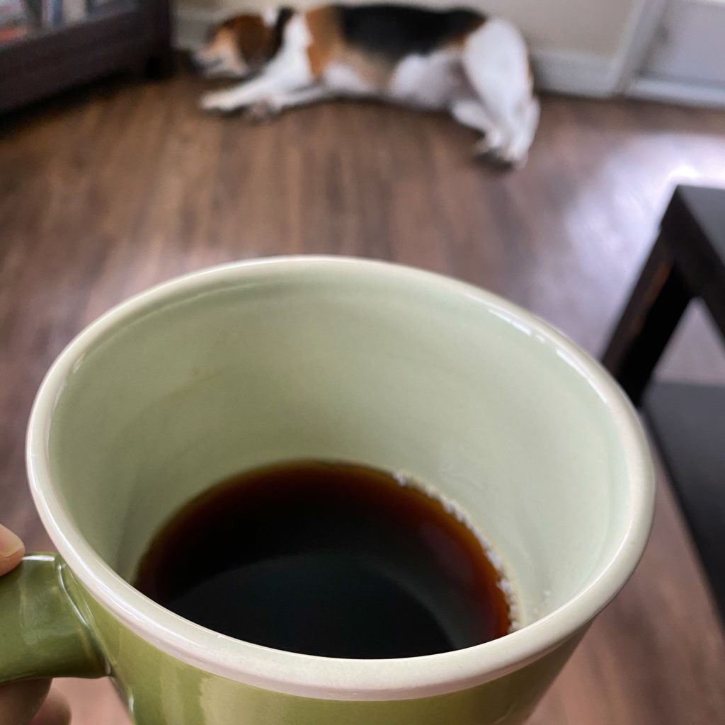 black coffee with dog in background